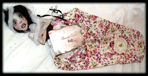Annabel ghost doll in her distressed and singed traveling sack with handmade card